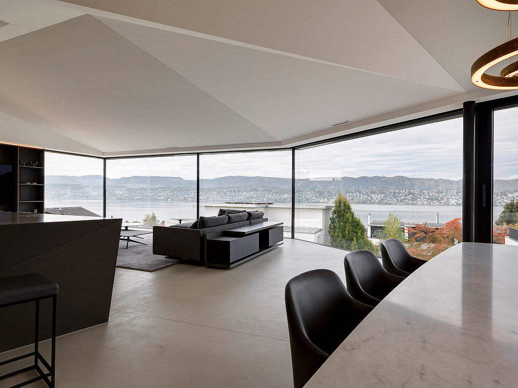 Sleek, modern interior with expansive glass walls overlooking a scenic cityscape.