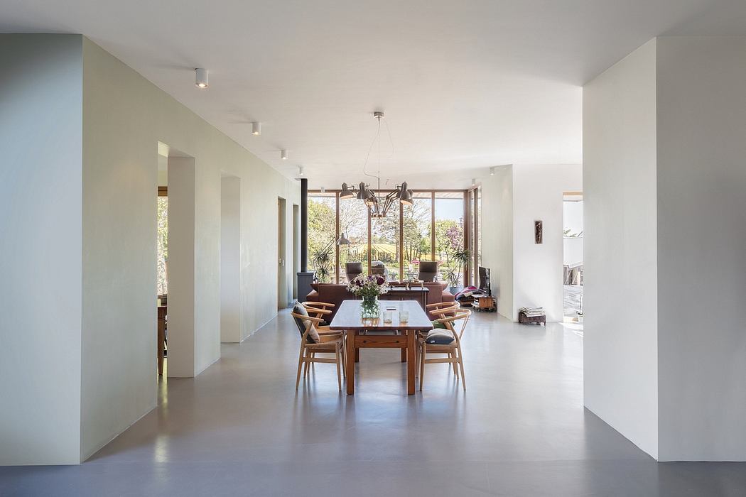 Spacious, modern open-plan living area with wooden dining table and comfortable seating.