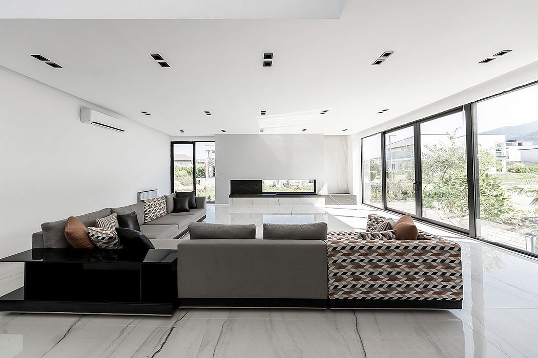 Minimalist living room with sleek furniture, large windows, and modern lighting fixtures.