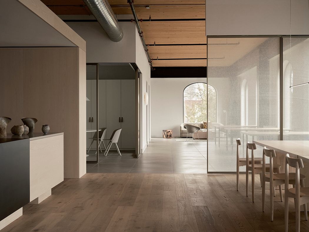 A modern, open-concept interior featuring warm wood accents, large windows, and a minimalist aesthetic.