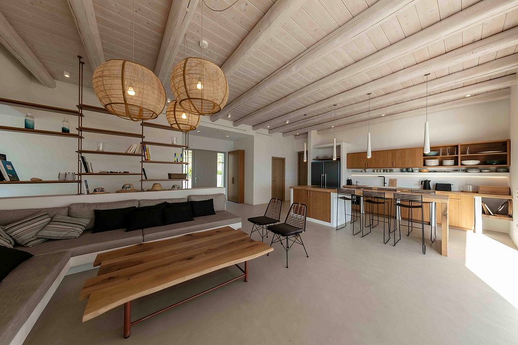 Spacious open-concept living area with wooden beamed ceiling, modern lighting, and minimalist furnishings.