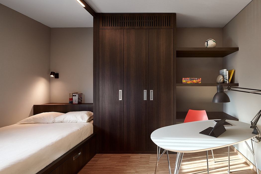 Cozy bedroom featuring dark wood cabinetry, minimalist desk, and textured wall panels.
