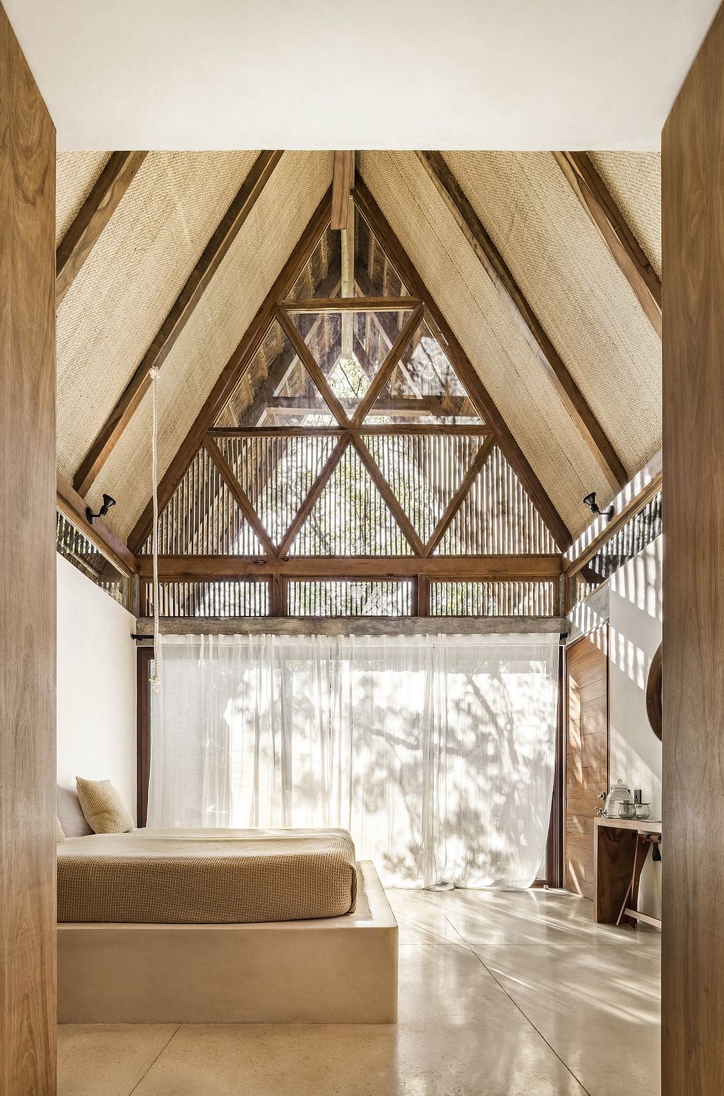 Rustic wooden beams, geometric patterns, and large windows create a warm, inviting space.