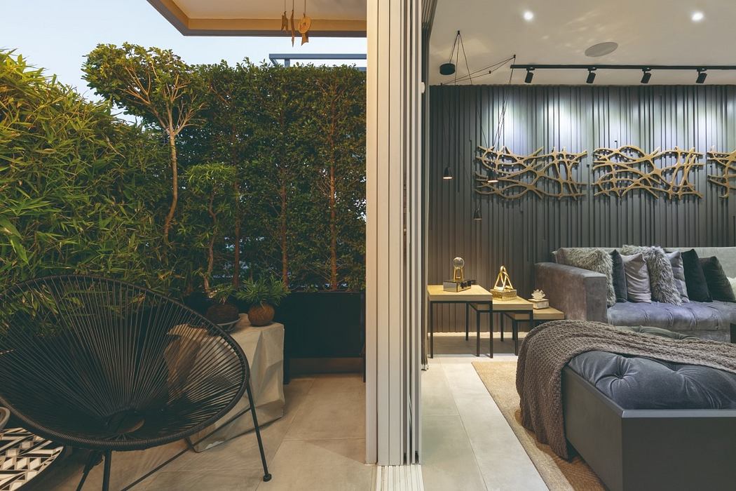 Expansive indoor-outdoor living space with lush greenery and modern furniture.