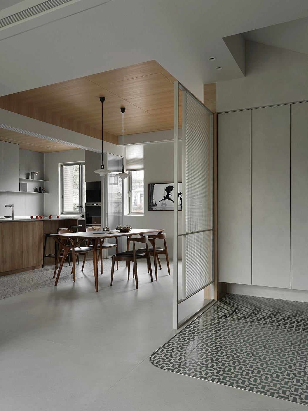Sleek, modern kitchen with wood accents, pendant lights, and patterned floor tiles.