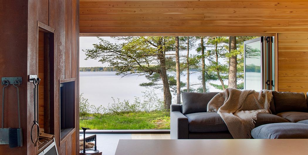 Cozy cabin interior with panoramic lakefront view, wooden walls, and sliding doors.