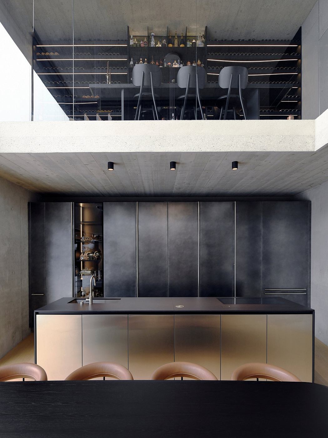 Sleek concrete bar with black cabinetry, leather barstools, and extensive bottle display.