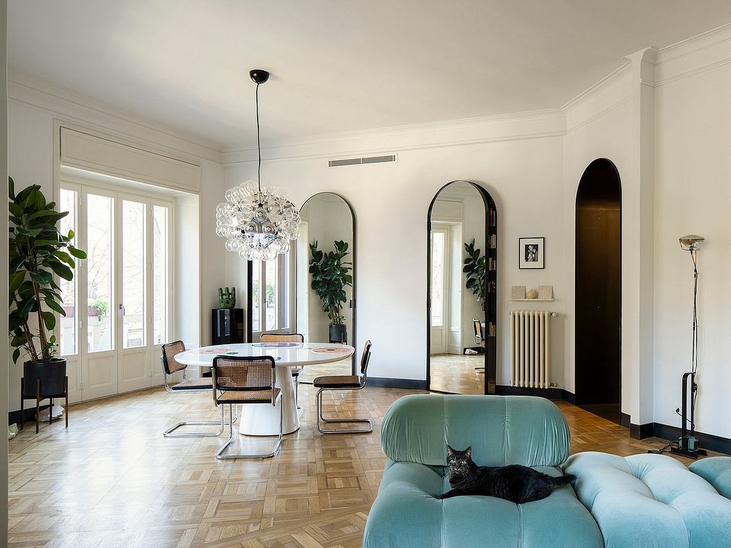 A spacious living room with high ceilings, large windows, and a striking crystal chandelier.