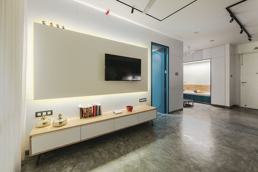 Modern living room with sleek TV wall unit, floating bench, and concrete floor.
