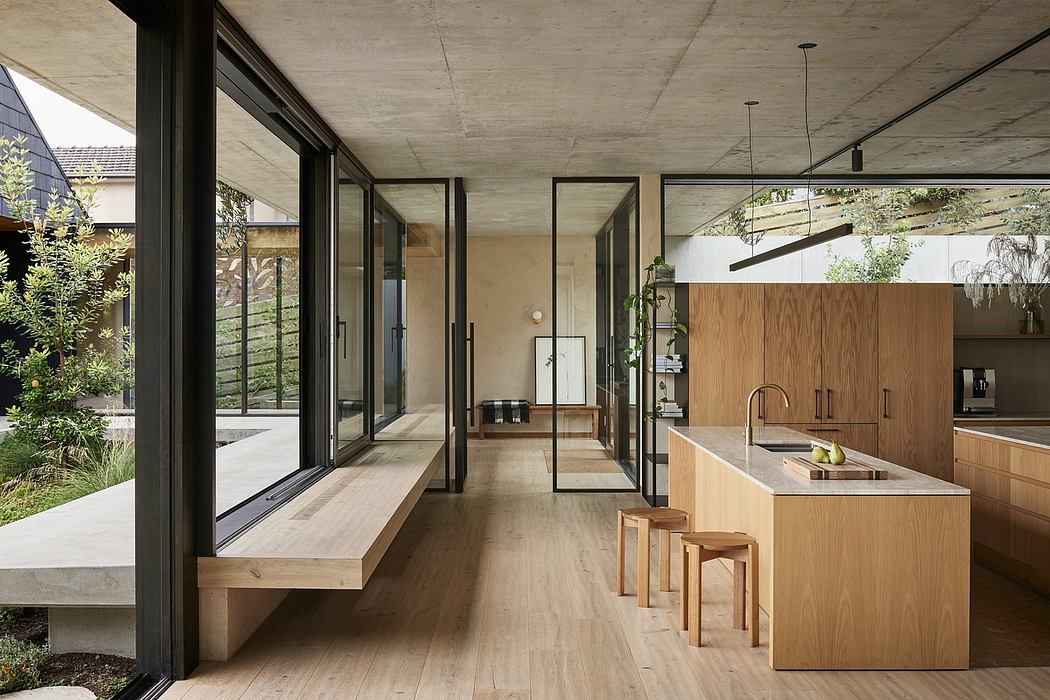 Minimalist open-plan kitchen and living area with wood accents, concrete ceiling.