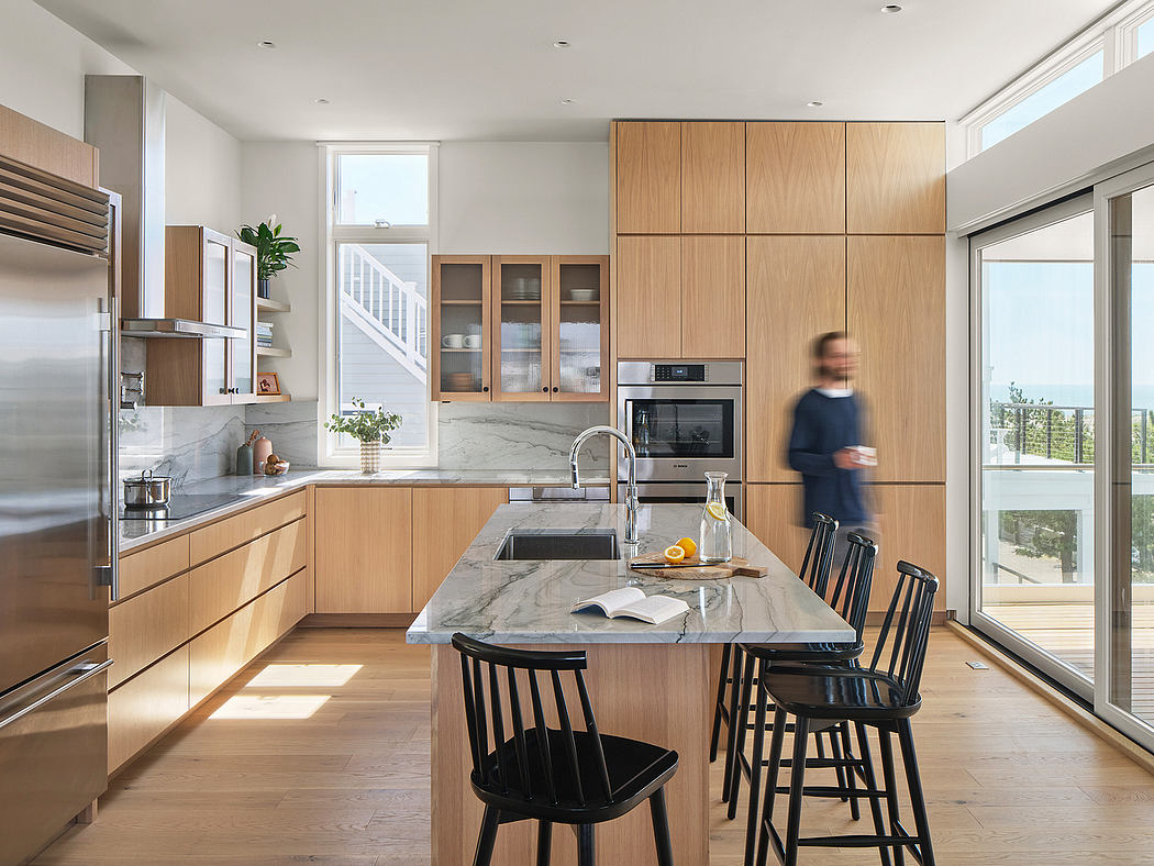 Sleek, modern kitchen with wooden cabinetry, marble countertops, and a cozy dining area.