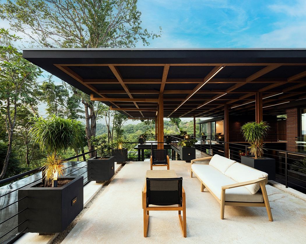 Outdoor patio with modern wooden beams, sleek furniture, and lush green foliage.