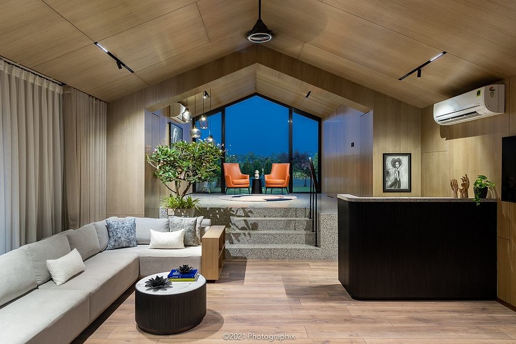 Modern open-concept living space with wood ceiling, large windows, and sleek furnishings.