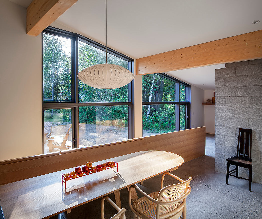Spacious modern dining area with large windows overlooking a natural landscape.