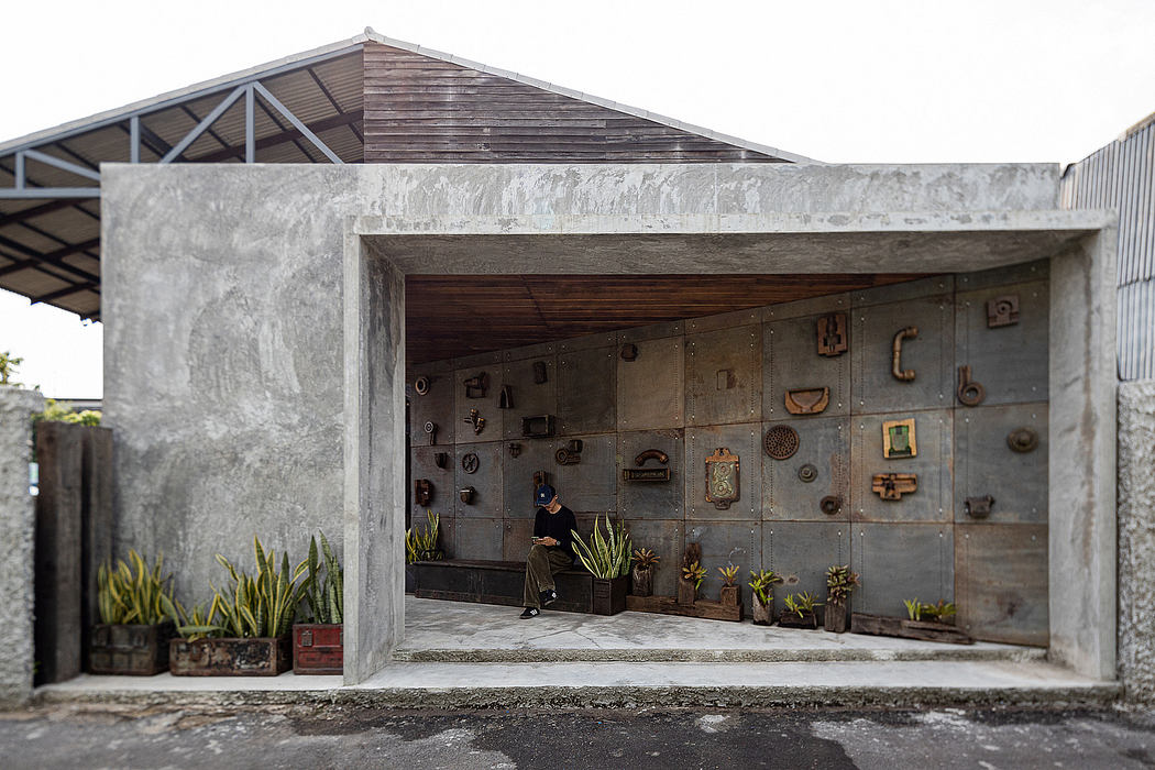 Rustic concrete structure with ornate wall displays and potted plants in the entryway.