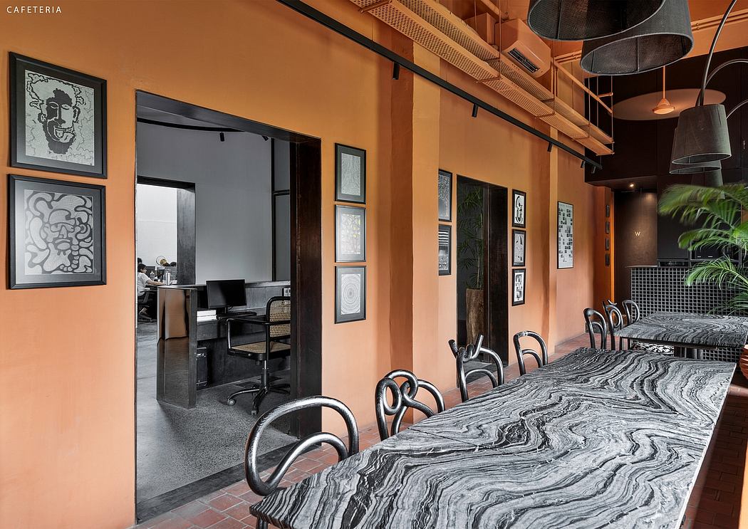 A visually striking cafeteria with vibrant orange walls, bold artwork, and a sleek marble table.