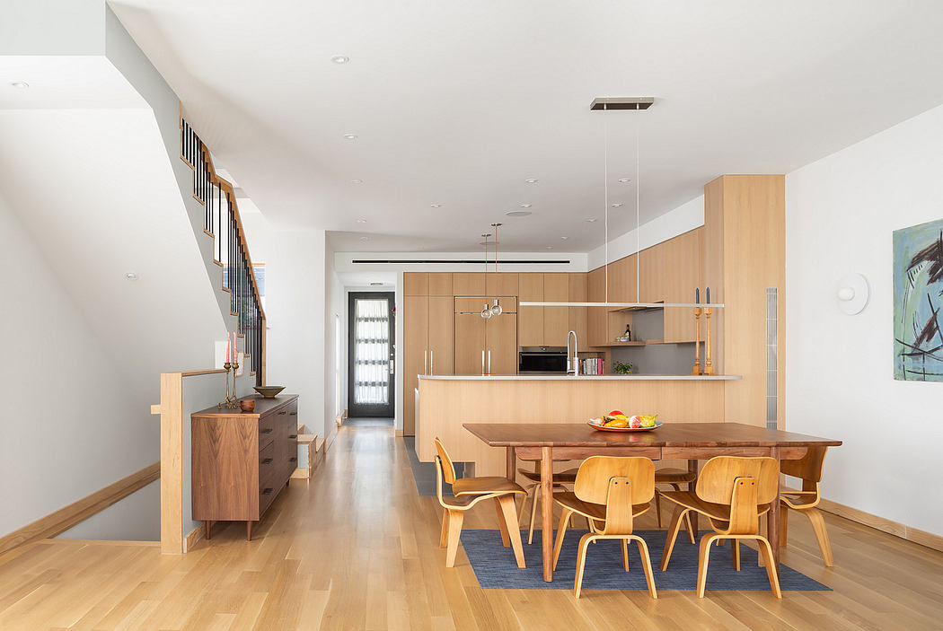 Contemporary open-plan kitchen and dining area with wooden furnishings and hardwood flooring.