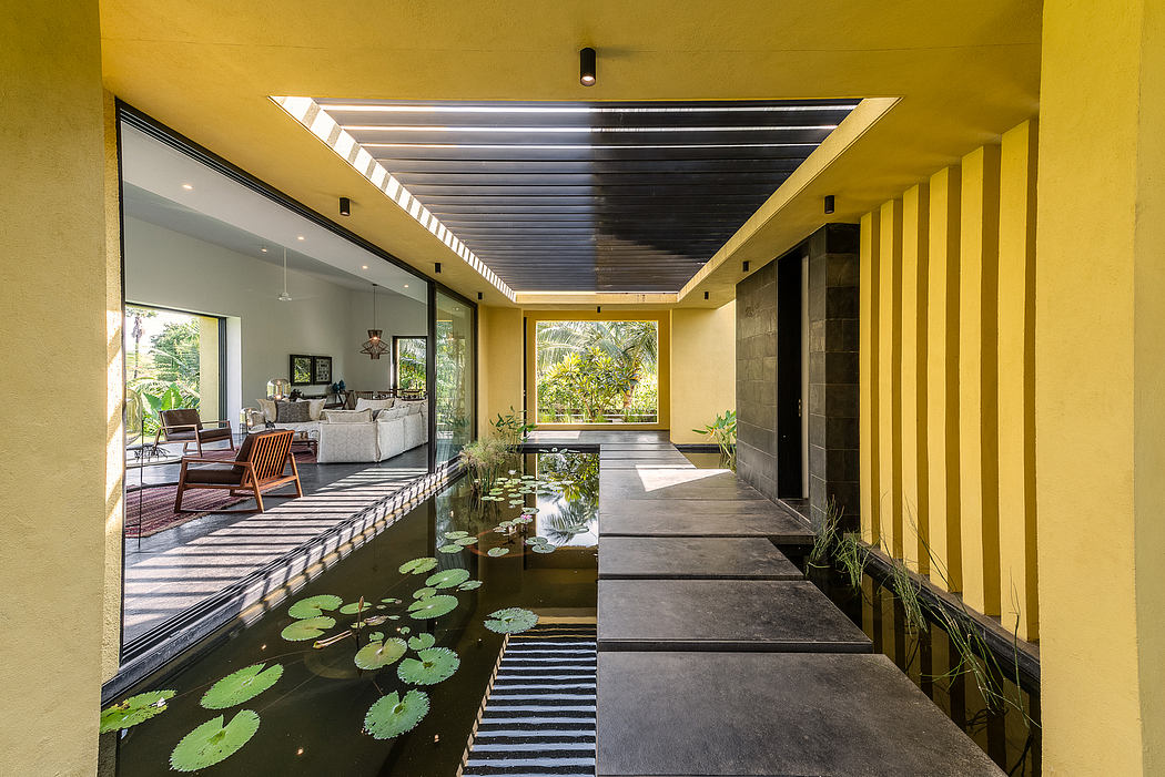 Sleek, modern architecture with a water feature and lush greenery inside the home.