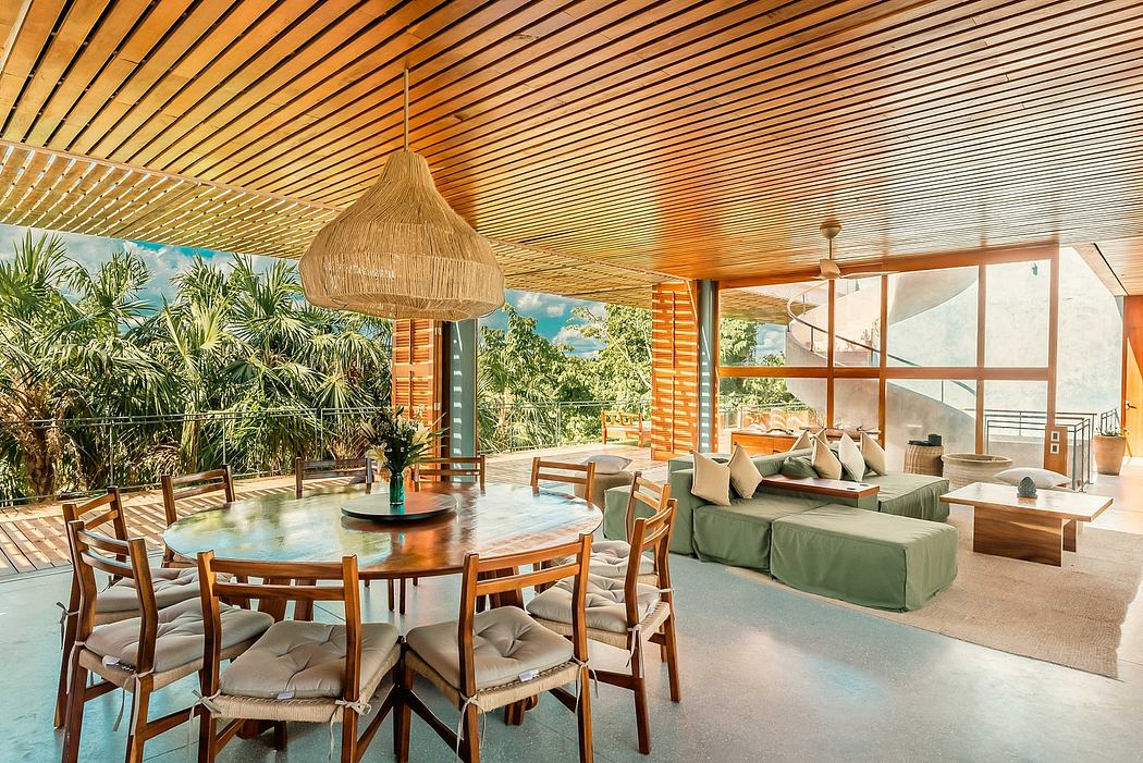 Spacious, open-concept living space with wooden beams, tropical foliage, and modern furnishings.
