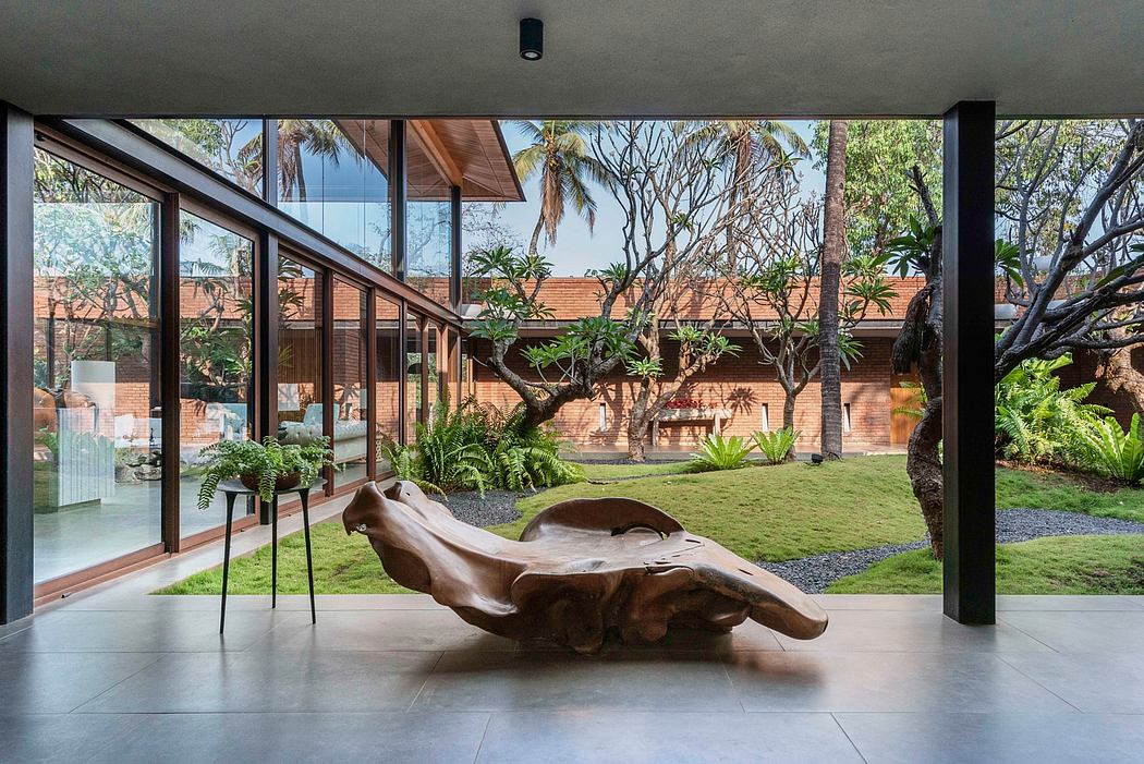 A lush, tropical indoor-outdoor living space with modern architecture and natural elements.