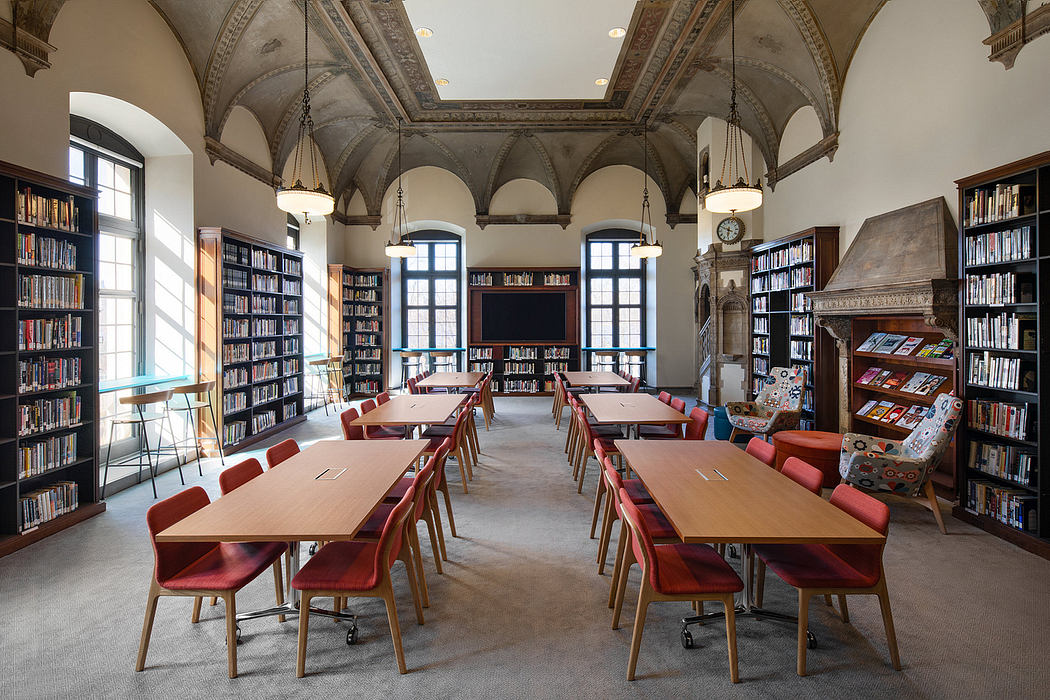 A magnificent library with vaulted ceilings, arched windows, and rows of wooden tables and chairs.