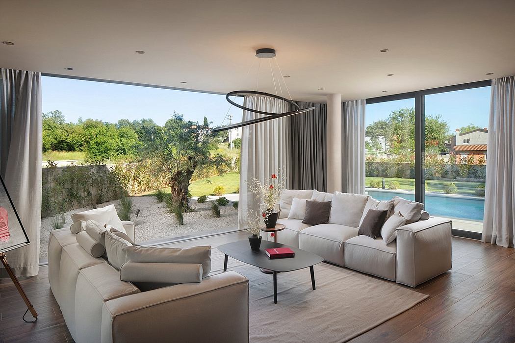 Spacious modern living room with large windows and contemporary lighting fixture.