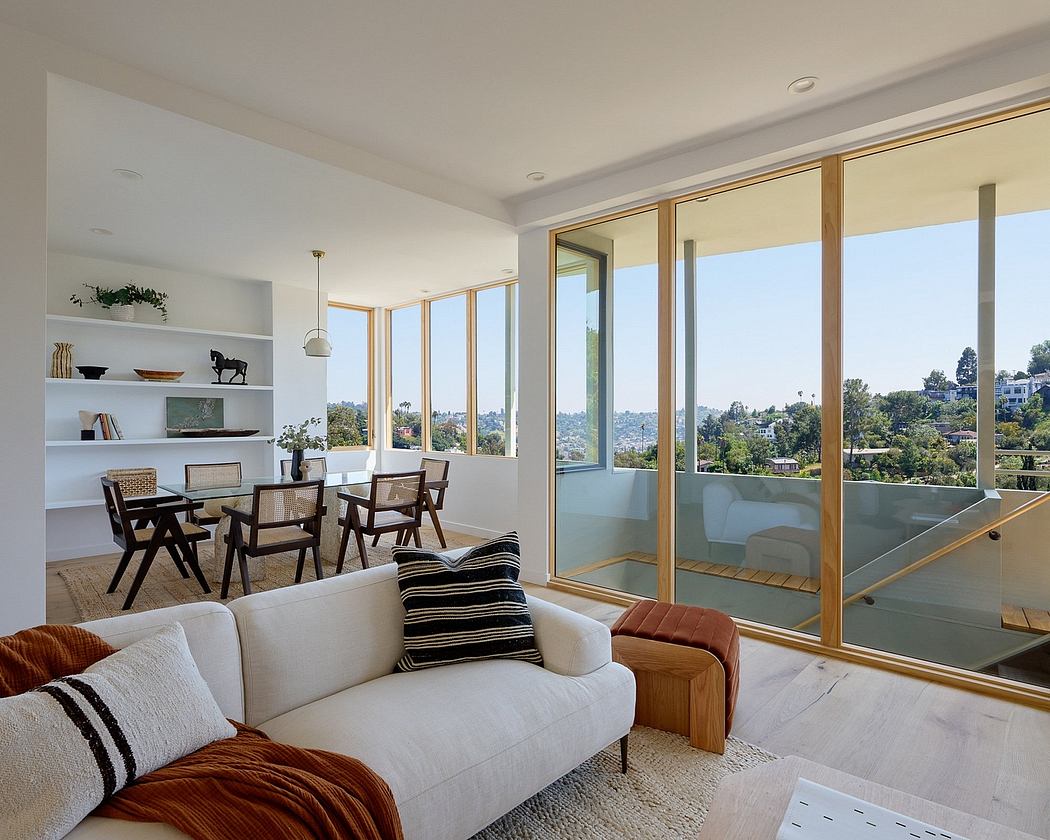 Expansive windows, light-filled living space with dining area and cozy seating.