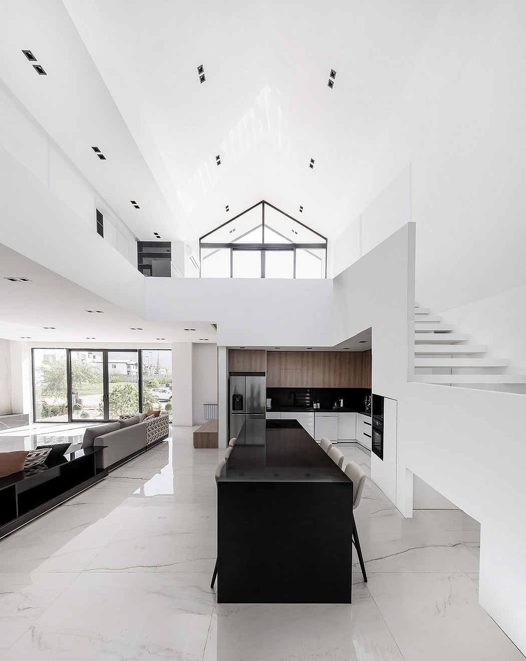 Sleek, modern interior with high ceilings, open kitchen, and minimalist furniture.