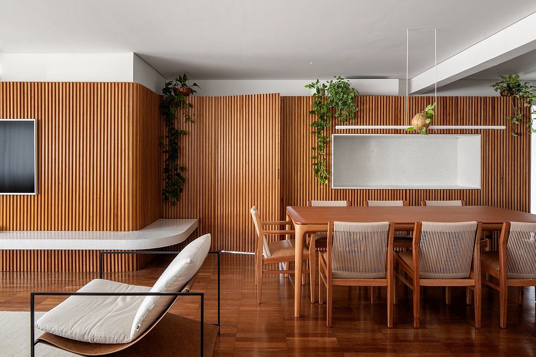 Warm, modern interior with wood paneled walls, dining table, and potted plants.