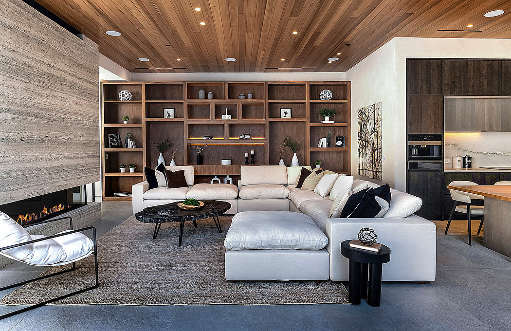 A spacious, modern living room with a wooden ceiling, built-in shelving, and a large sectional sofa.