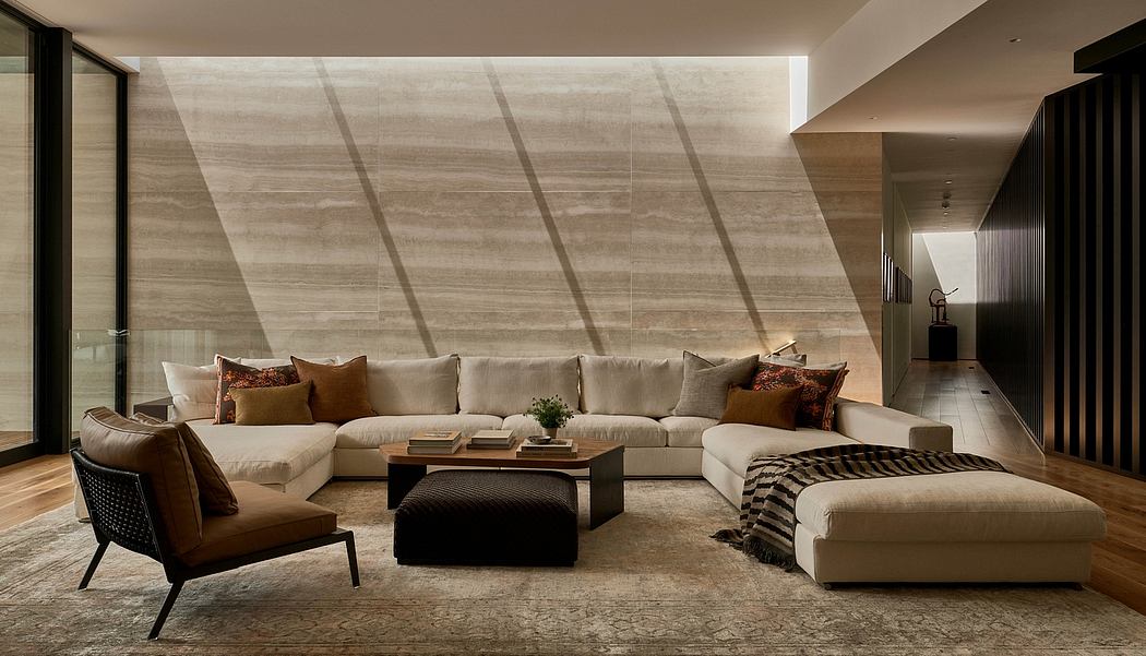 Large open-concept living room with textured stone walls, plush sectional, and wooden coffee table.