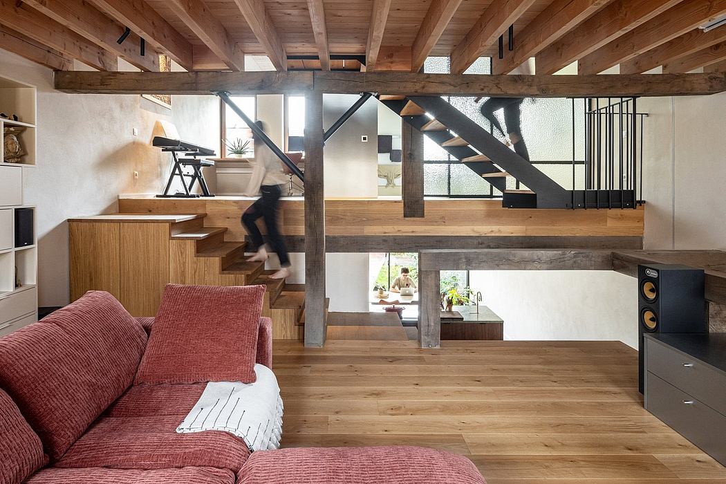Rustic open-concept loft with wooden beams, metal stairs, and integrated storage.