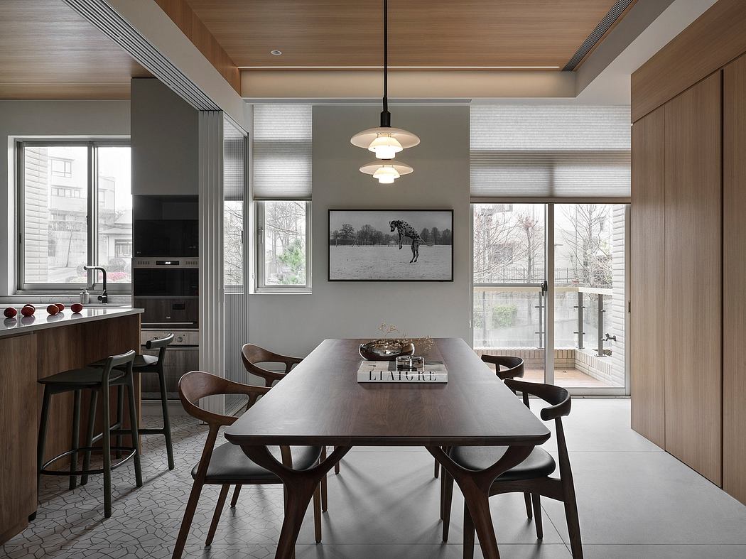 Sleek, modern kitchen-dining space with wooden accents, large windows, and statement lighting.