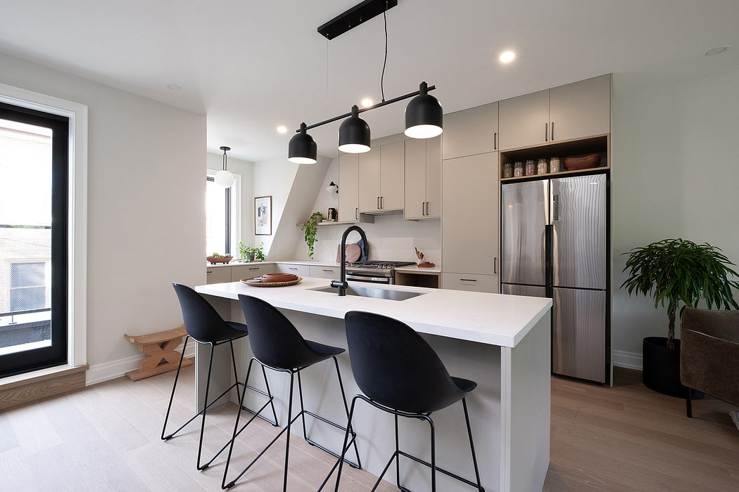 Sleek modern kitchen with white countertops, black pendant lights, and stainless steel appliances.