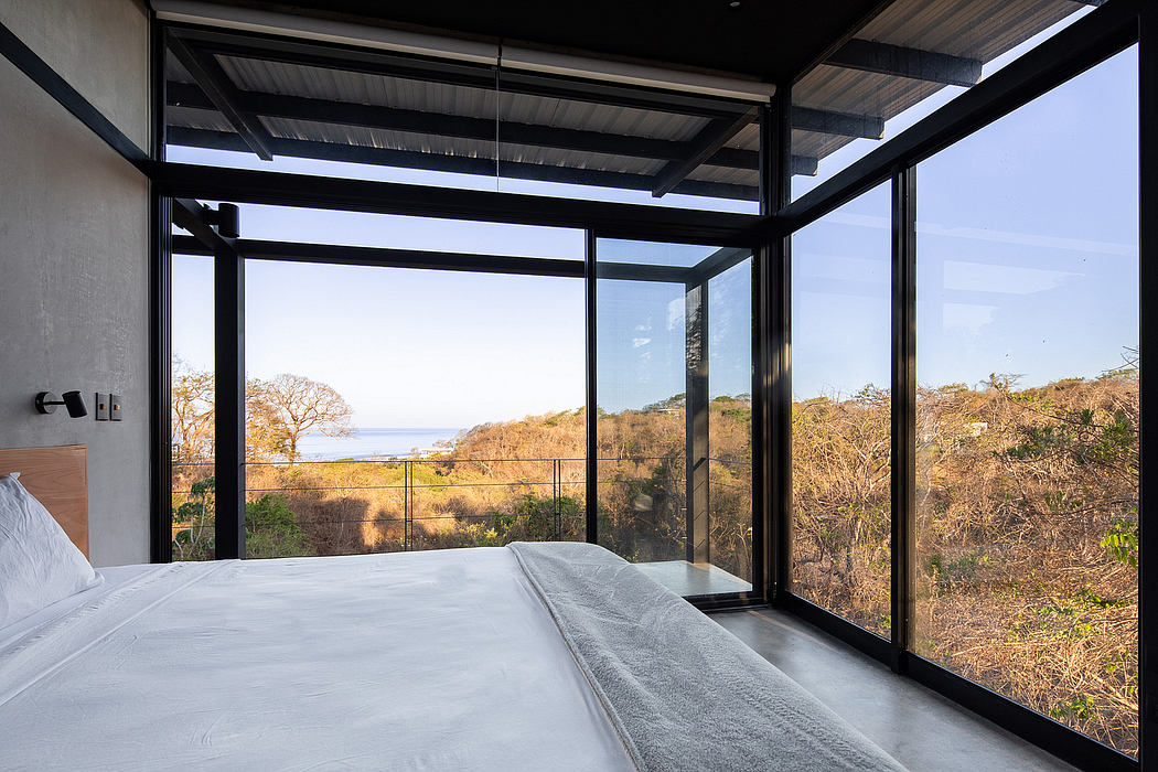 A modern, open-concept bedroom with panoramic views of the surrounding landscape.