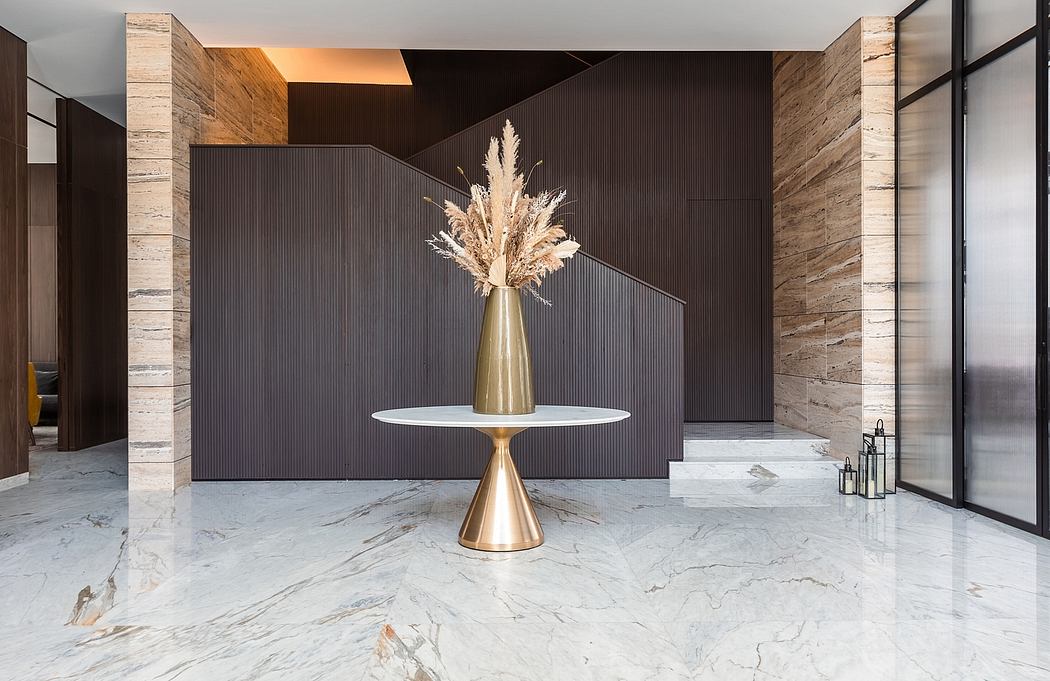 Sleek modern interior with lustrous marble floor, metallic accent table, and striking pampas grass display.