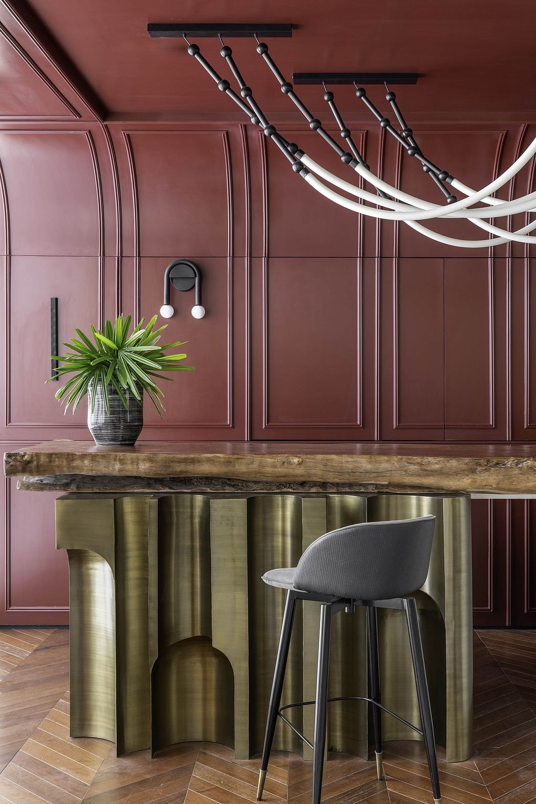 Warm-toned paneled walls, modern brass accents, and a rustic wood countertop create an inviting interior.