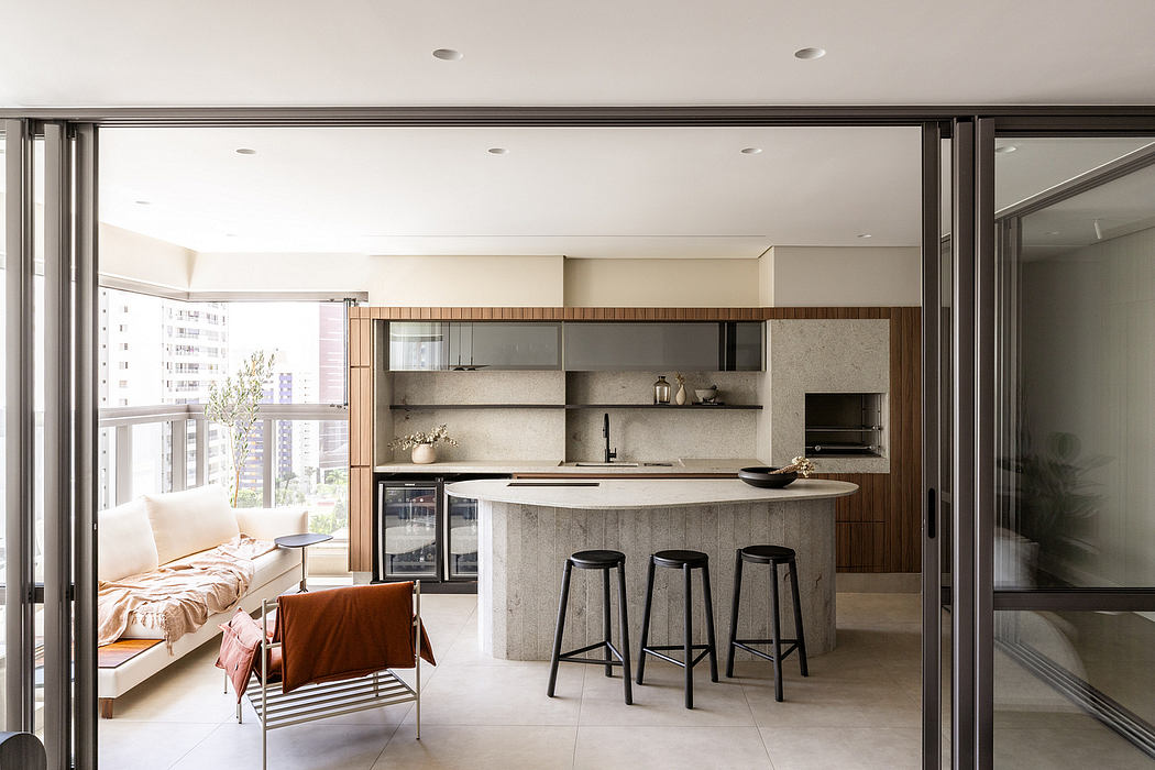 Sleek, modern kitchen with integrated appliances and a concrete-topped island, adjacent to a cozy living area.