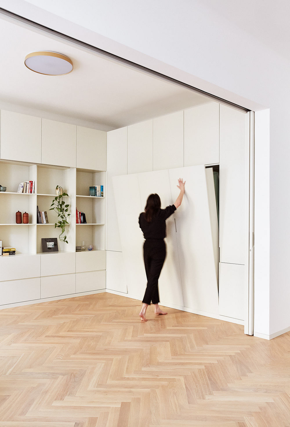 Sleek, minimalist interior with built-in cabinetry, white walls, and hardwood flooring.