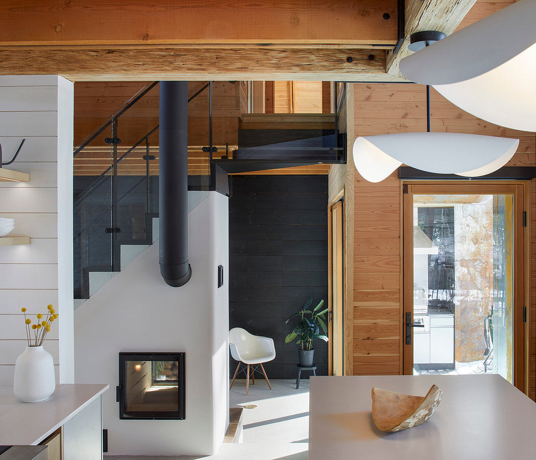 A modern, open-concept interior with wood beams, industrial lighting, and minimalist furnishings.