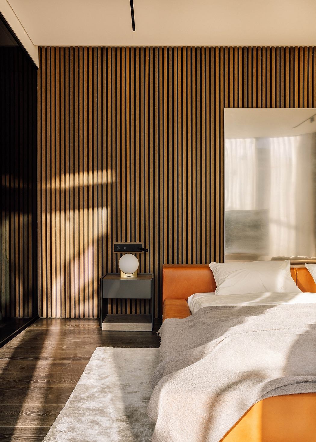 Minimalist bedroom design with sleek wooden slat wall, modern nightstand, and cozy bedding.