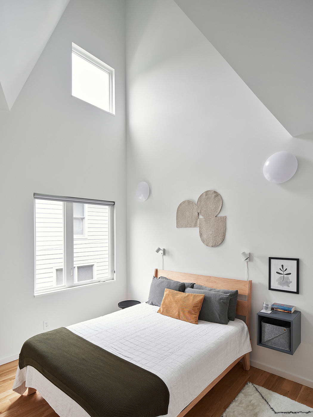Bright, modern bedroom with high ceilings, wooden bed frame, and minimalist decor.