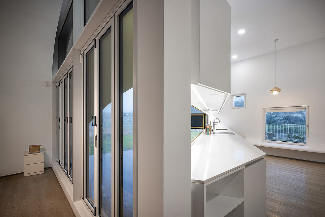 Spacious, modern interior with large windows, open-concept kitchen, and sleek design elements.