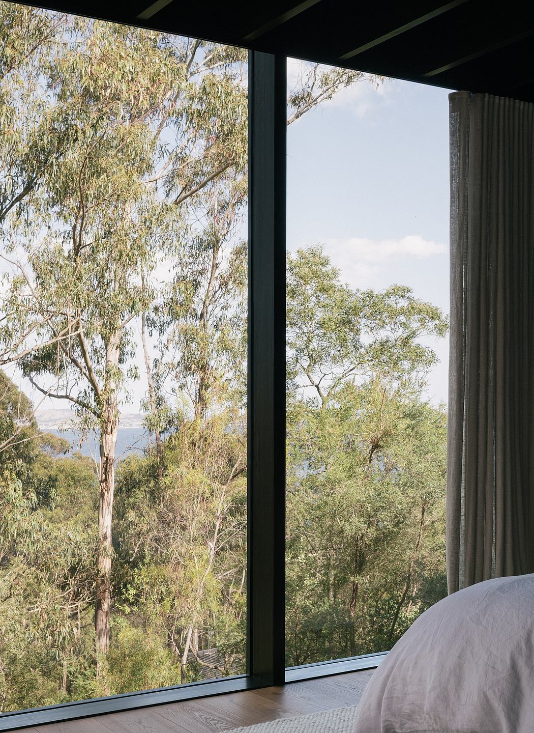 Floor-to-ceiling windows provide stunning views of the lush, forested landscape.