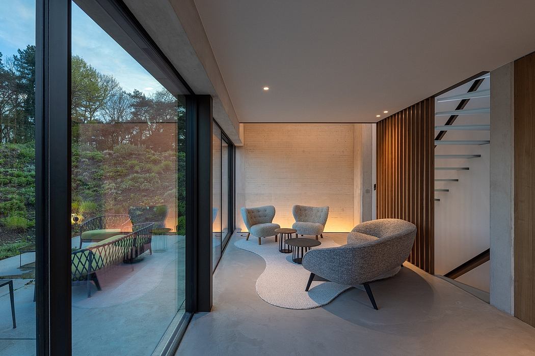 Modern living room with large windows, wood accents, and plush gray furniture.