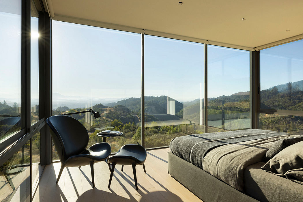 Expansive floor-to-ceiling windows frame a stunning mountain landscape panorama.