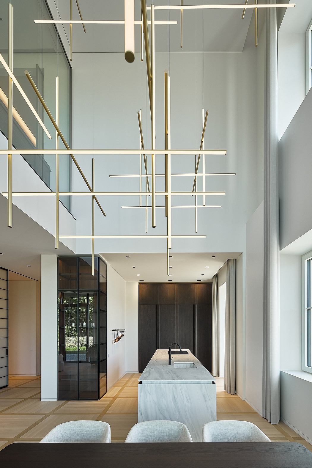 Sleek modern interior with striking gold geometric light fixtures and marble island.