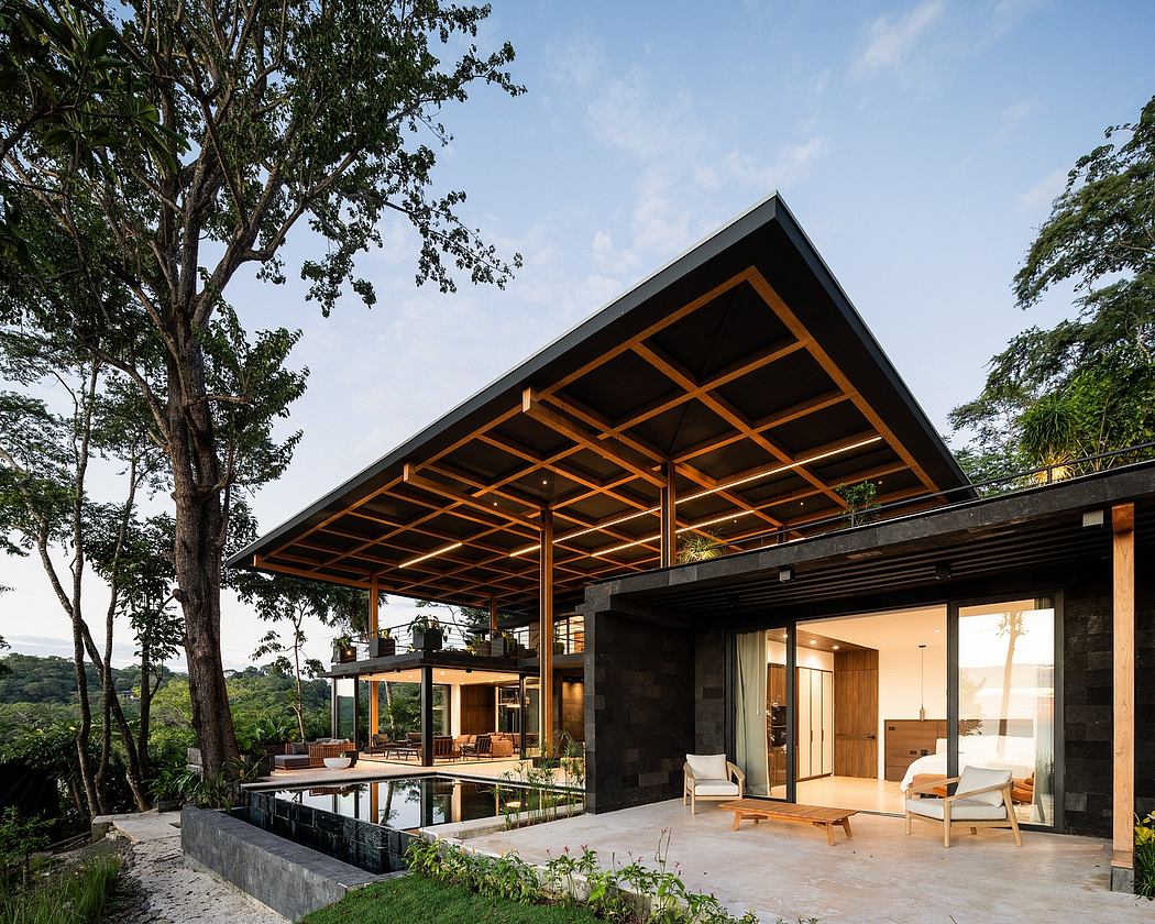 Striking modern structure with expansive wooden roof and large glass walls overlooking nature.