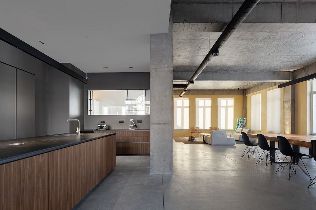 Loft-style interior with open kitchen, concrete walls, and modern furnishings.