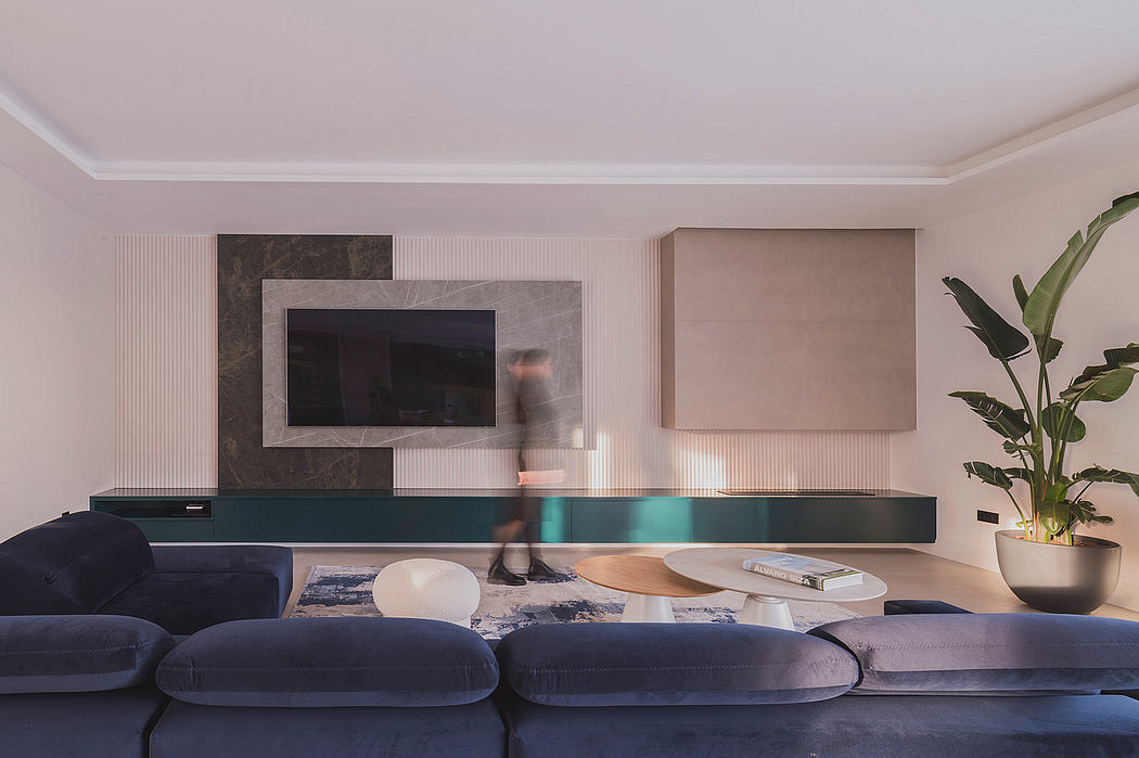 Modern living room with minimalist furniture, sleek TV console, and potted plants.